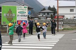 川崎町交通指導隊小学生へ手をあげて横断歩道を渡るように促す様子